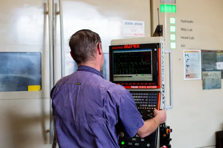 Machine operator checking on the progress of the CNC milling machine producing a part for a client in Australia