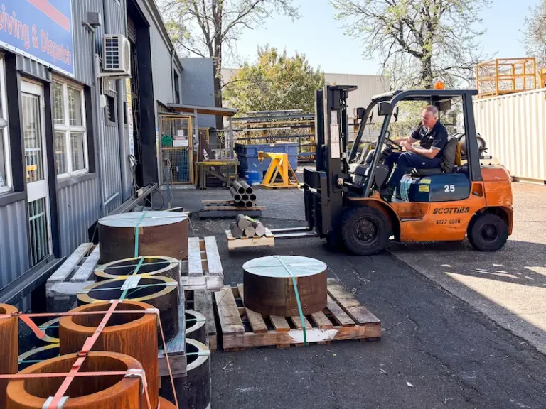 ABCO Precision Machining employee operating a forklift to move raw metal material that will become a part