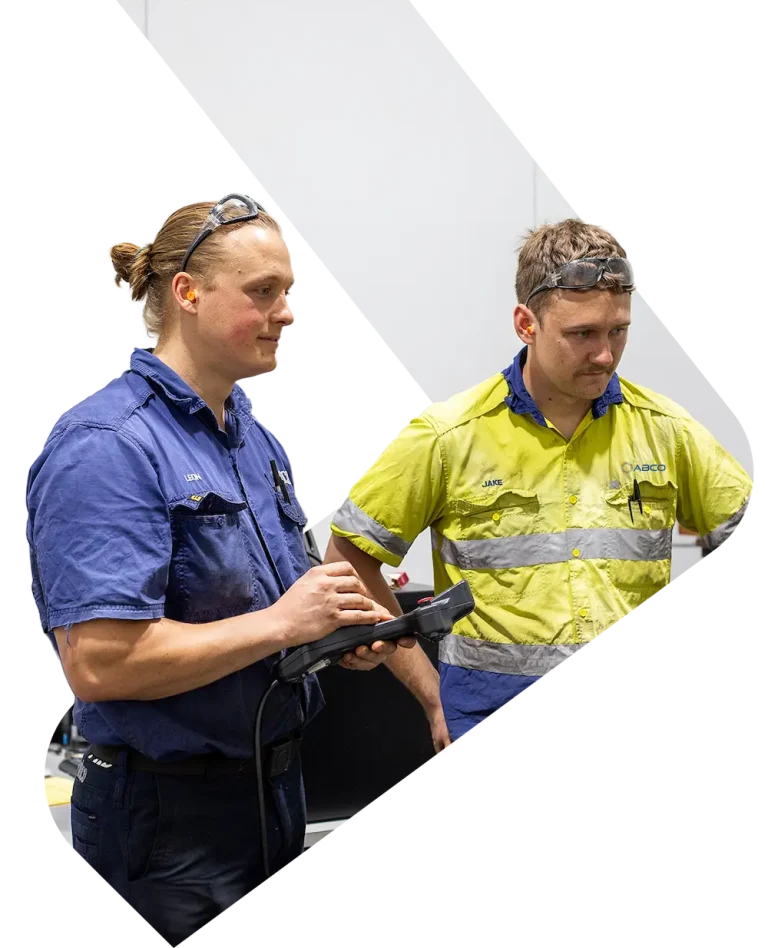 Decorative image of two ABCO Precision Machining employees working on a CMM machine